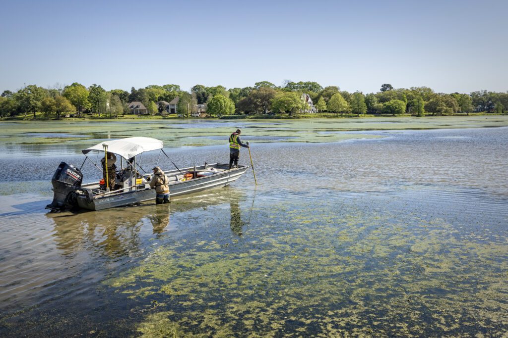 enstermaker survey technicians, from left, Richard Tauzin, Kyle Lanclos and Erick Kidder pull their boat through shallow water in City Park Lake while mapping the lake's depth Thursday, April 1, 2021.